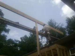Carpenter setting a ridge beam over a new addition frame — Ice Dam Removal by Roofing Brothers in Fort Hall