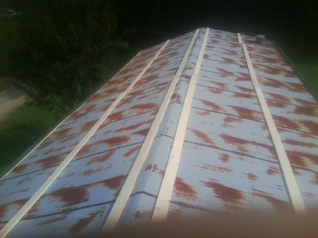 Rusted metal roof panels with new wood purlins before replacement — Storm Damage Roof Repair in Fort Hall by Roofing Brothers
