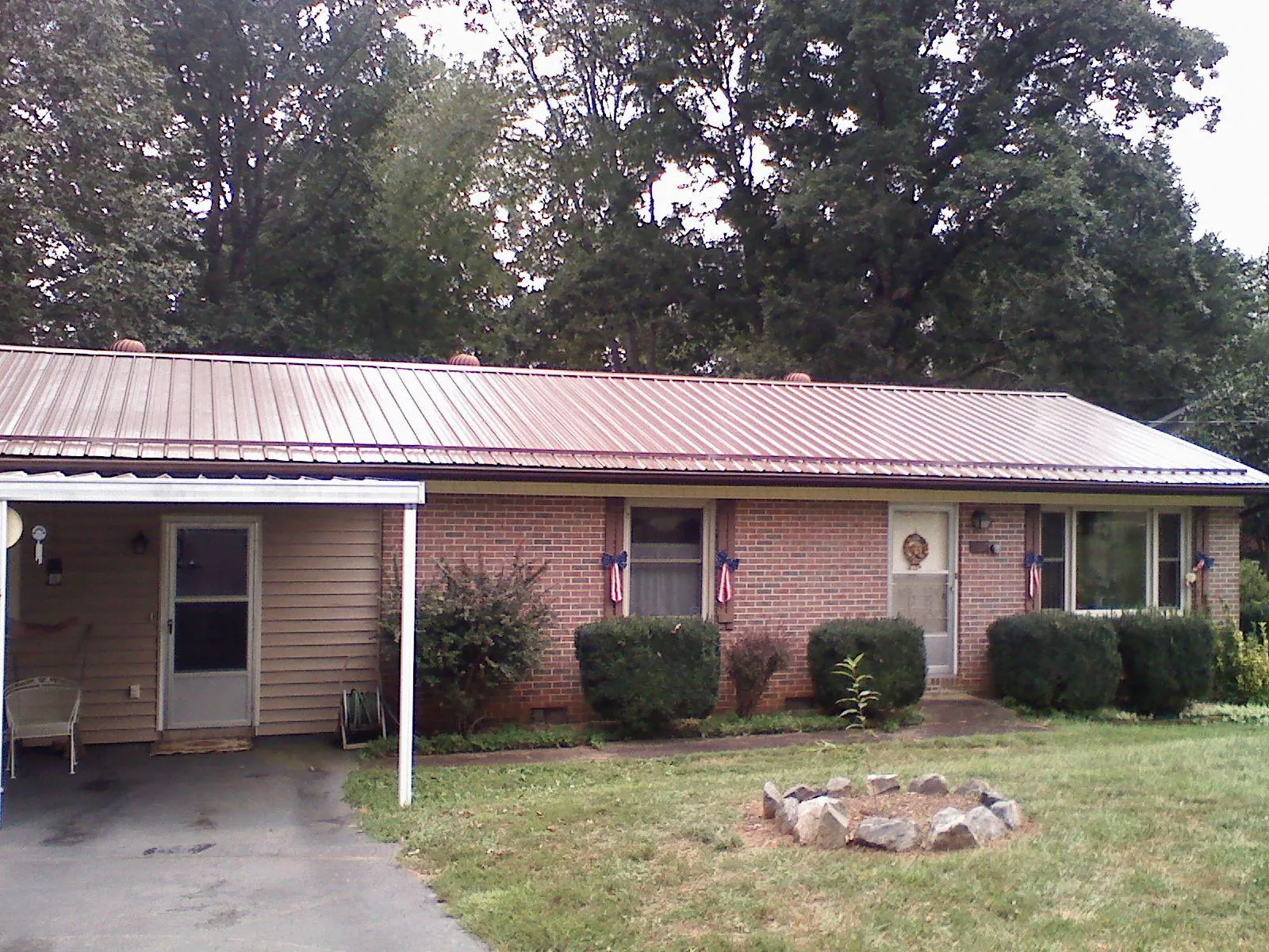 Bronze metal roof and carport on a brick ranch home — Roof Repair work by our crew in Fort Hall